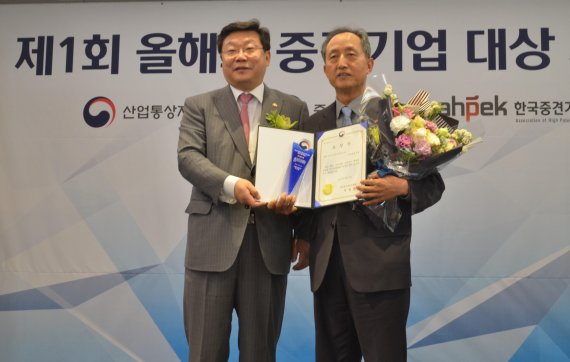 서울 소공동 롯데호텔에서 지난 8일 열린 제1회 올해의 중견기업 대상 시상식에서 오경환 샘표식품 전무(오른쪽)가 주형환 산업통상자원부 장관으로부터 장수기업 부문 대상을 받은 뒤 기념촬영을 하고 있다.