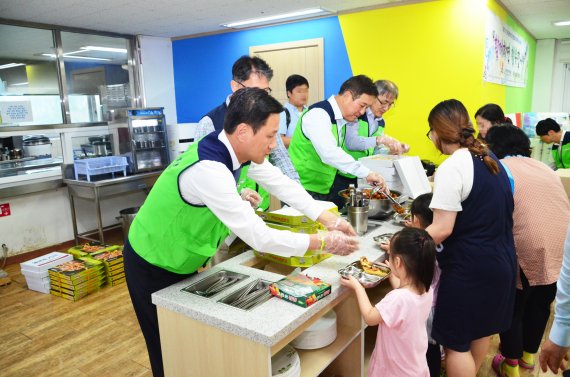 한국프랜차이즈산업협회 임직원과 사회봉사단원들이 23일 서울 강남 강남드림빌에서 어린이들에게 저녁식사를 배식하고 있다.