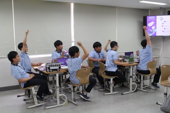 LG CNS의 코드 지니어스 교육에 참여한 서울 경성중학교 학생들이 발표를 위해 손을 들고 있다.