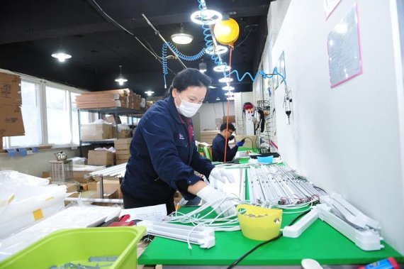 발광다이오드(LED) 조명기구를 제조, 판매하는 필립인텍스의 직원들이 제품을 조립하고 있다.