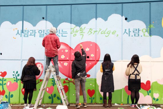 사람인에이치알 임직원으로 구성된 아람인 봉사단원들이 서울 구로구에 위치한 도로에서 벽화그리기 활동을 진행하고 있다. /사진=사람인에이치알