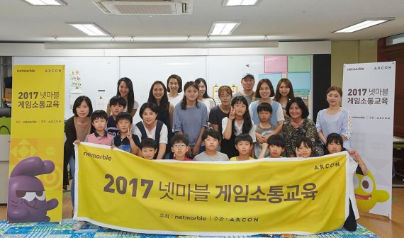 지난 21일 경기도 용인 제일초등학교에서 열린 넷마블게임소통교육에 참여한 넷마블 관계자들과 학생, 학부모들이 기념촬영을 하고 있다.