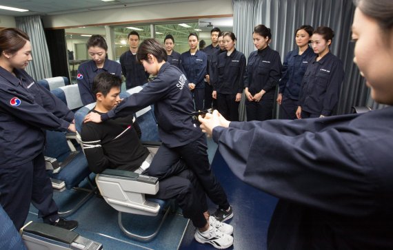대한항공 승무원들이 서울 공항동 객실훈련센터에서 전기충격기와 포승줄 등을 사용해 기내 난동 승객을 제압하는 훈련을 시연하고 있다.