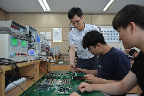 방학 기간을 이용, 주문식 맞춤훈련에 참여한 스마트전자과 학생들이 정원근 지도교수(왼쪽 첫번째)로부터 마이크로 컨트롤러를 이용, 생산자동화제어 프로그램을 습득하고 있다.