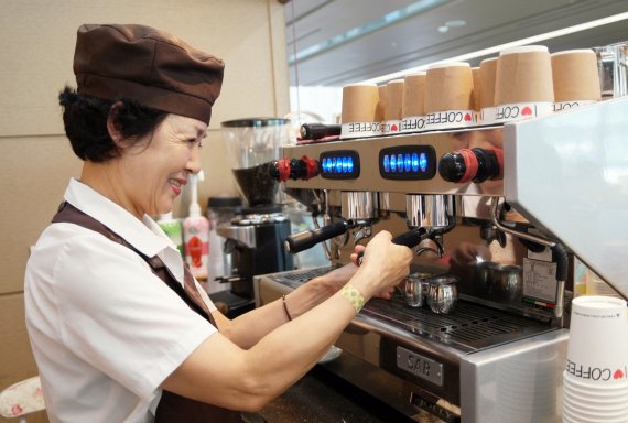 삼성전자 '카페 휴' 용인수지구청점에서 근무하는 신정희 시니어 바리스타가 커피를 만들고 있다.