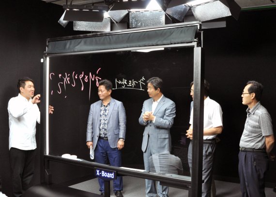 지난 26일 부경대 김영섭 총장(가운데)과 남송우 기초교양교육원장(오른쪽 두번째) 등 '블랙 스튜디오' 개소식 참석자들이 시스템 시연 후 설명을 듣고 있다.