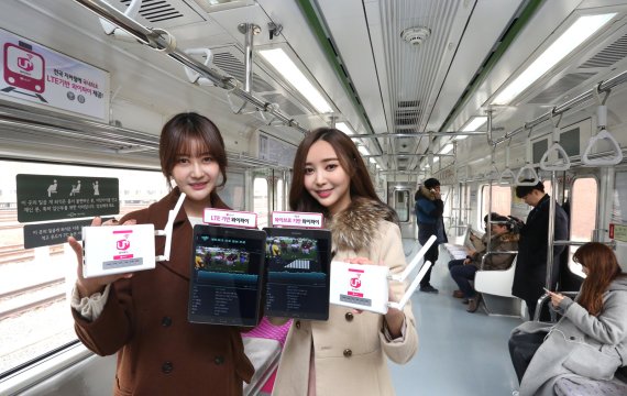 LG유플러스 모델들이 지하철 객차 내에서 와이파이 서비스를 이용하고 있다.