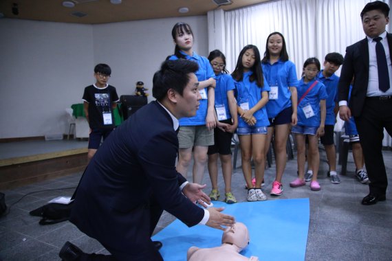 보안전문기업 ADT캡스 직원이 지난 14일 경기도 안성 너리굴문화마을에서 임직원 자녀들에게 심폐소생술을 가르치고 있다.