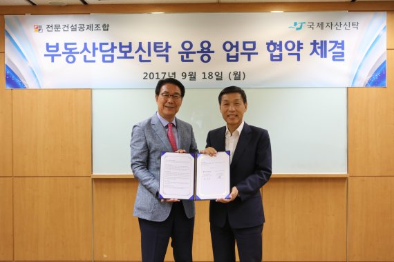 18일 전문건설공제조합 손명선 전무이사(왼쪽)와 국제자산신탁 유재은 회장이 부동산담보신탁 운용 업무 협약을 체결한 후 기념촬영을 하고 있다.