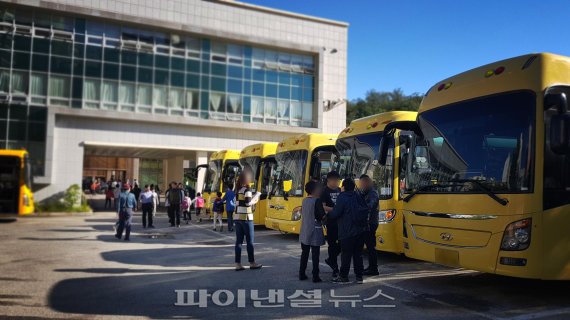 ▲정진학교의 7개 통학버스에서 장애학생들이 등교를 하고 있다. 한 학생이 학교를 가지 않겠다며 부모와 선생님이 실랑이를 벌이고 있다.