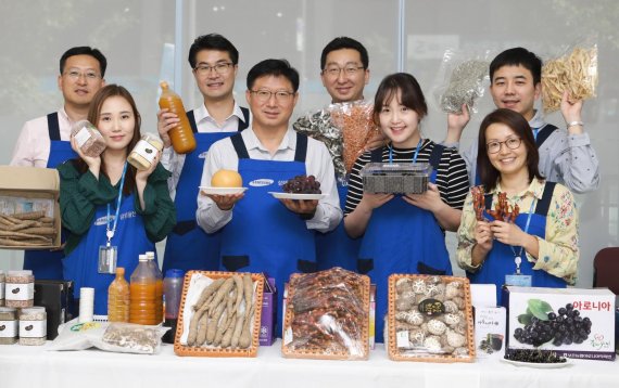 삼성물산 임직원들이 25일 경기 성남시 판교역로 본사에서 자매결연 마을과 추석 직거래 장터에서 자매마을 특산품을 들고 환하게 웃고 있다.