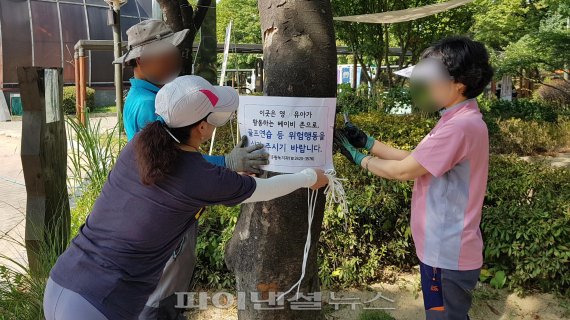 ▲ 공원 관리 직원이 '골프연습 등 위험행동을 삼가주시기 바립니다'고 적힌 안내면을 베이비 존 곳곳에 붙이고 있다.