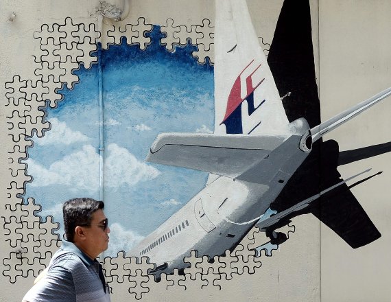 지난 2016년 3월 8일 말레이시아 셀랑고르주 샤알람에서 한 시민이 말레이시아 항공 MH 370편을 추모하는 벽화 옆을 지나고 있다.AFP연합뉴스