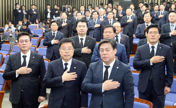 자유한국당 정우택 원내대표와 의원들이 30일 오전 국회에서 열린 의원총회에서 국기에 대한 경례를 하고 있다. 이날 한국당 의원들은 검은양복을 입고 의총에 참석했다. /사진=연합뉴스