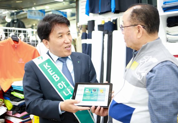 함영주 KEB하나은행장(왼쪽)이 서울 동대문종합상가를 찾아 '태블릿브랜치'로 상인에게 금융거래 상품을 설명하고 있다.