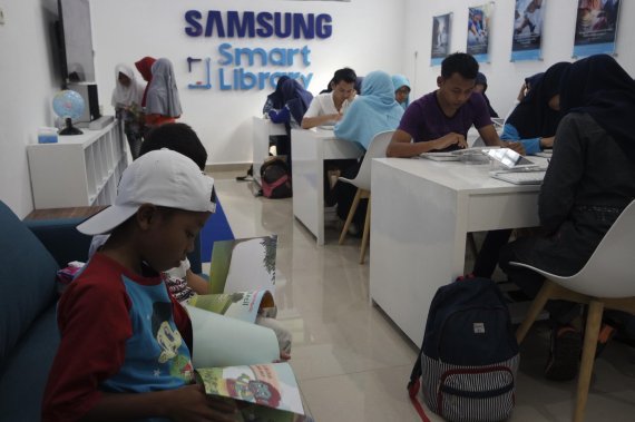 지난 5월 인도네시아 로오사리 마을에 삼성전자와 글로벌 비정부기구(NGO) '해비타트'가 함께 건립한 '삼성 스마트 도서관'에서 현지 학생들과 주민들이 정보기술(IT) 기기를 활용하고 있다.