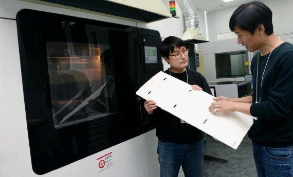 LG전자 연구원들이 3D프린터로 만들어낸 냉장고 부품을 살펴보고 있다.