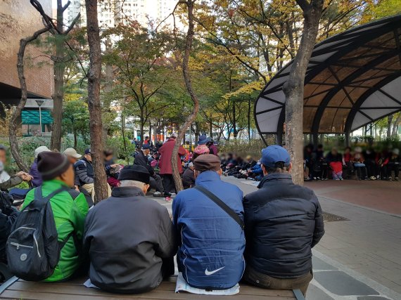 지난 9일 오전 7시 서울 서초구 '파랑새 어린이공원'에 노인 100여명이 줄지어 앉아 있다. 이들은 공원 인근 교회와 성당에서 주는 500원을 받기 위해 이곳에 모였다./사진=최용준 기자