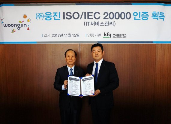 이재진 웅진 대표이사(오른쪽)이 서울 을지로 본사에서 열린 ISO/IEC20000인증 수여식에서 남대현 한국품질재단 대표와 기념촬영을 하고 있다.