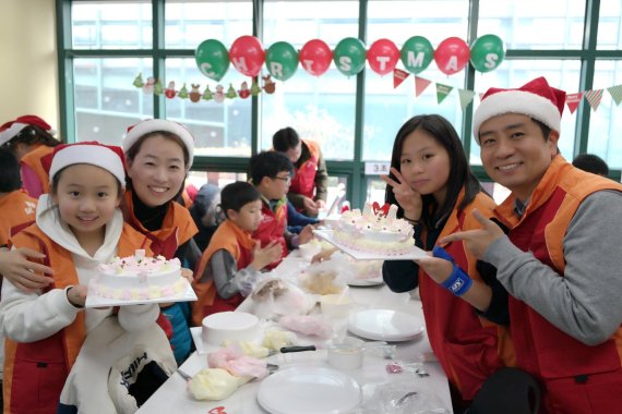 SK건설 임직원과 가족 100여명이 지난 25일 밀알복지재단과 서울 강남구직업재활센터에서 '사랑의 케이크' 만들기 가족 봉사활동을 진행한 뒤 기념촬영을 하고 있다.