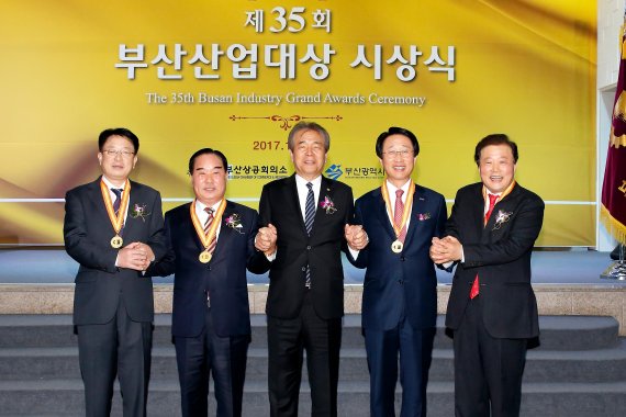 부산상공회의소가 제정·시행하고 부산시가 후원하는 ‘제35회 부산산업대상’ 시상식이 11월30일 부산 범천동 부산상의 2층 상의홀에서 열렸다. 제35회 부산산업대상에는 △경영대상 은산해운항공(주) 양재생 대표이사 △기술대상 금성볼트공업(주) 김선오 대표이사 △봉사대상 에어부산(주) 한태근 대표이사 △근로복지대상 (주)동성화학 이경석 대표이사가 최종 수상자로 선정됐다. 부산산업대상 시상식에서 조성제 부산상의 회장(가운데)이 수상자들과 함께 기념사진을 찍고 있다.