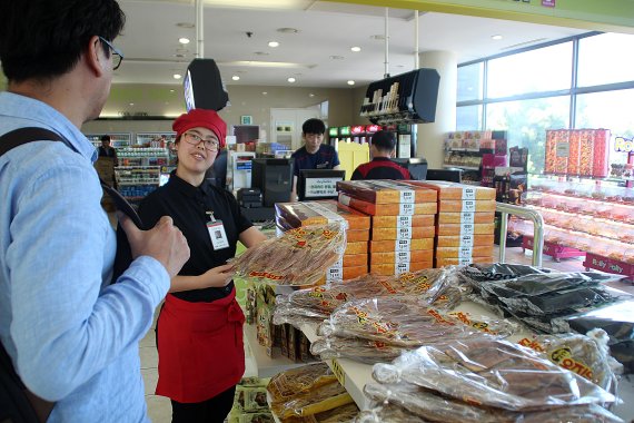 옥계휴게소 직원이 고객에게 지역 특산품인 오징어를 소개하고 있다.