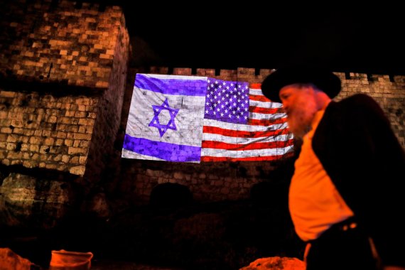 6일(현지시간) 이스라엘 예루살렘 구시가 벽의 이스라엘 국기옆에 성조기 영상이 비치고 있다. 이날 베냐민 네타냐후 이스라엘 총리는 '이스라엘 수도는 예루살렘'이라는 도널드 트럼프 미국 대통령의 공식 선언에 "역사적이고 용감한, 정당한 결정"이라고 평가했다. AFP연합뉴스