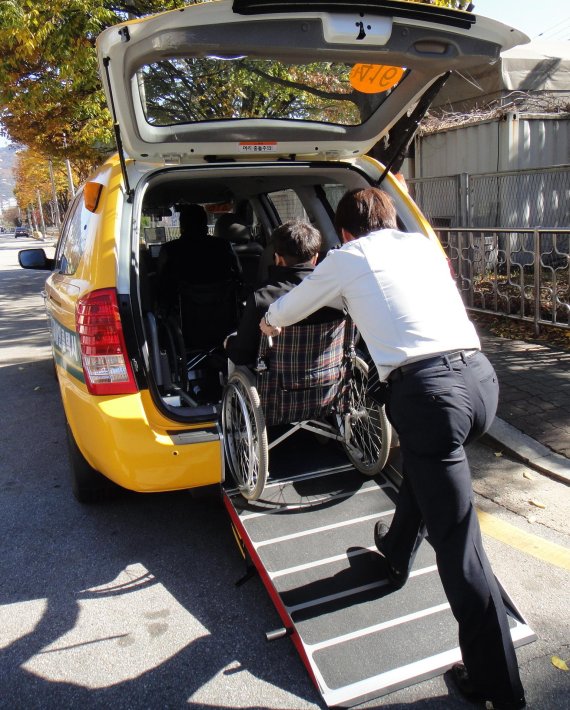 한 장애인이 운전기사의 도움을 받아 서울시 장애인 콜택시에 승차하고 있다. 서울시설공단 제공