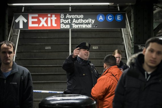 미국 뉴욕 맨해튼 '포트 오소리티'(Port Authority) 버스터미널로 이어지는 지하통로에서 폭발물 테러가 일어난 11일(현지시간) 한 경찰관이 출구를 통제하고 있다.AFP연합뉴스