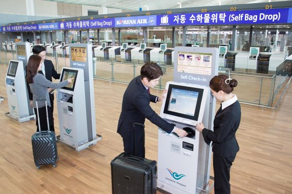 대한항공 직원들이 12일 개항을 한 달여 앞둔 인천국제공항 제2여객터미널의 셀프체크인 기기 사용을 시연하고 있다.