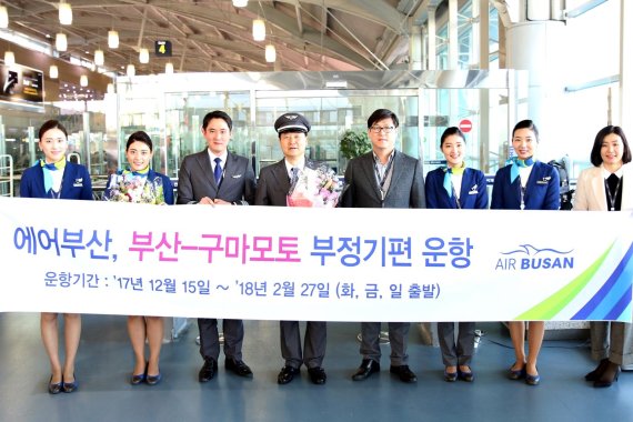 에어부산 관계자들이 김해공항에서 15일 부산~구마모토 노선 부정기편 운항 개시를 기념해 기념촬영을 하고 있다.