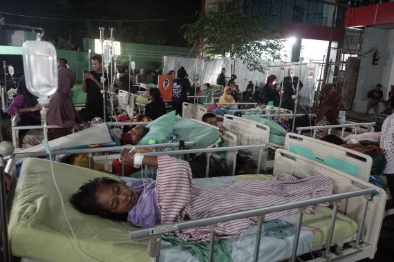 16일(현지시간) 인도네시아 자바섬 중부 바뉴마스에 위치한 한 공공병원 건물 밖에서 지진 피해자들이 치료를 받고 있다. EPA연합뉴스