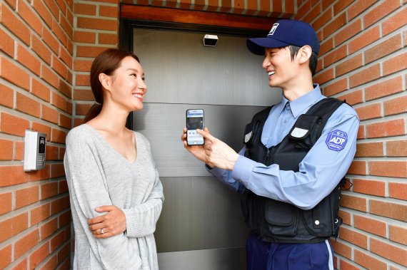 ADT캡스 직원(오른쪽)이 일반 가정에서 합리적인 가격으로 사용할 수 있는 홈 보안 서비스 '캡스홈'에 대해 설명하고 있다.