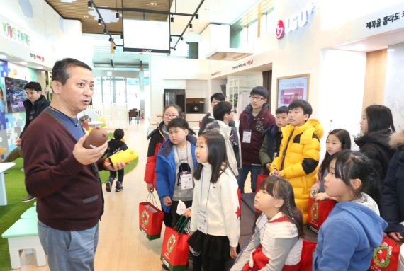 권영수 LG유플러스 부회장(왼쪽)이 지난 22일 용산 사옥에서 어린이들에게 AI스피커 ‘프렌즈+’를 선물 한 후 다양하고 편리한 기능들을 소개하고 있다.