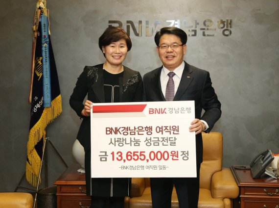 BNK경남은행 여직원들이 공익재단인 BNK경남은행사랑나눔재단에 이웃돕기 성금을 전달하고 있다.