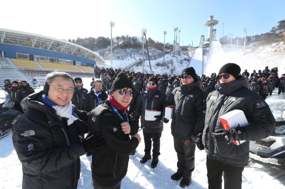 KT 황창규(앞줄 왼쪽) 회장이 10일 강원도 평창 스키점프센터 앞에서 현장 직원들에게 혹한에도 따뜻하게 평창동계올림픽을 준비할 수 있도록 '발열조끼'를 입혀주고 있다.