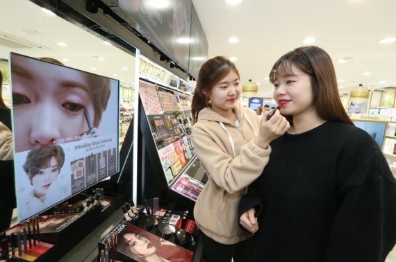 스마트스토어로 리뉴얼한 네이처컬렉션 신촌점에서 고객이 메이크업 디스플레이존을 체험하고 있다.