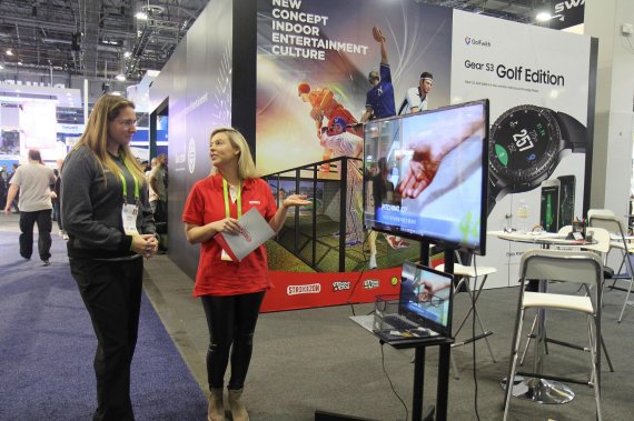 뉴딘콘텐츠 직원(오른쪽)이 'CES 2018' 참석자에게 스크린 스포츠 브랜드들을 설명하고 있다.