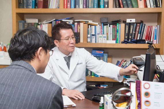권용욱 AG클리닉 원장(오른쪽)이 갱년기 남성환자에게 성장호르몬 치료에 대해 설명하고 있다.