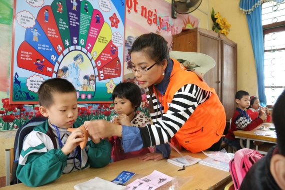 이주여성인 원태희 단원(한국어다문화학과)이 베트남 어린이에게 오카리나를 교육하고 있다.