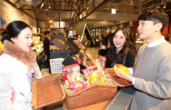 5일 AK플라자 분당점 식품관 ‘분당의 부엌’에서 남녀커플이 ‘DIY 과일선물세트’와 ‘햄퍼선물세트’를 구매하고 있다.