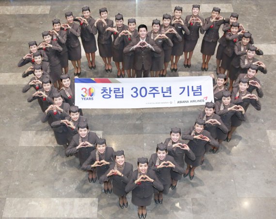 아시아나항공 신입 캐빈승무원들이 14일 서울 강서구 본사에서 창립 30주년을 기념해 축하 세레모니를 하고 있다. /사진=fnDB