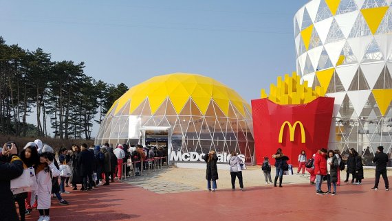 맥도날드가 평창 동계올림픽대회를 기념해 지난 9일 강원 강릉 올림픽파크에 오픈한 햄버거 세트 모양의 동계올림픽 파크 매장 앞에 지난 18일 매장에 들어가기 위해 이용객들이 길게 줄을 서 있다.