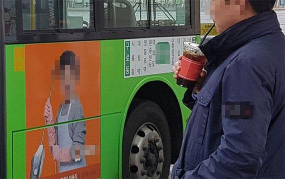 커피를 마시며 버스를 기다리고 있는 시민. 서울시는 지난달 4일 시내버스 재정 지원 및 안전 운행기준에 관한 조례를 개정했다. 테이크아웃 컵 등 음료를 들고 타는 승객의 승차를 거부할 수 있다. 사진=이혁 기자