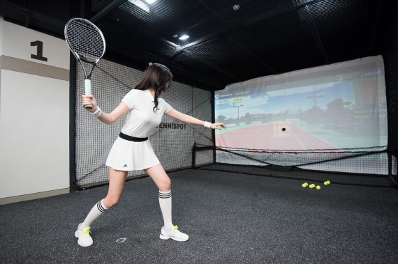 여성 테니스 동호인이 뉴딘이 운영하는 스크린 테니스장인 테니스팟에서 경기를 하고 있다.