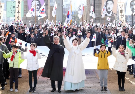 문재인 대통령과 부인 김정숙 여사가 1일 오전 제99주년 3.1절을 맞아 서울 서대문형무소 역사관에서 독립문까지 대형 태극기를 들고 행진한 뒤 만세 삼창을 하고 있다. 연합뉴스