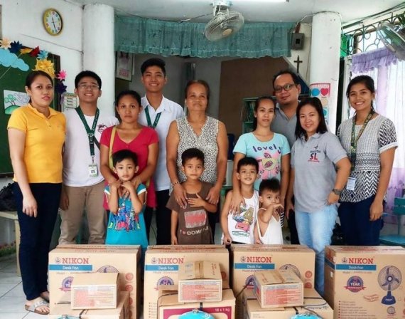 성공회대 학생들이 필리핀 바랑가이 타탈지역에서 봉사활동으로 인연을 맺은 유치원생 4명 가족에게 생필품을 전달한 뒤 포즈를 취하고 있다.