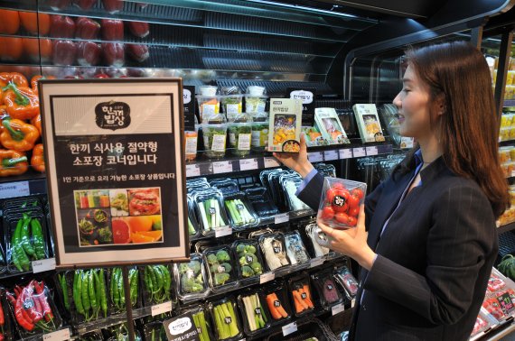 롯데백화 대구점 식품관을 찾은 여성고객이 '한끼밥상' 코너에서 야채를 고르고 있다.