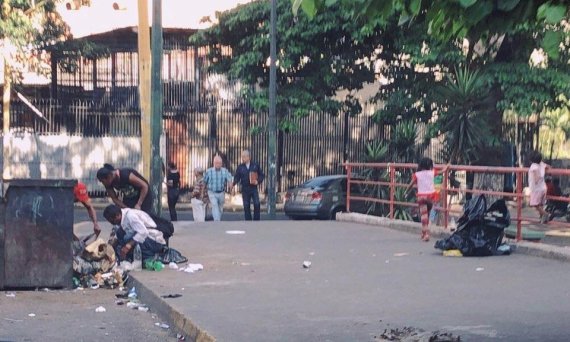 지난 3일 베네수엘라 카라카스 도심 한쪽 쓰레기 더미에서 노숙자 가족들이 음식을 찾고 있다. 이들의 4세, 7세 난 딸들은 부모가 음식은 찾는 동안 다리 난간에 매달려 시간을 보내고 있다. 사진=김문희 기자