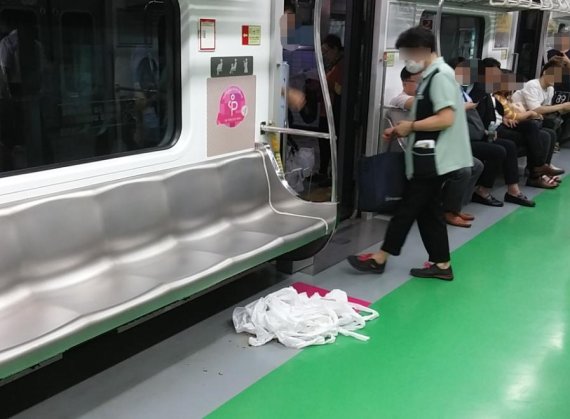 서울지하철 환경미화원이 전동차에서 취객이 게워낸 토사물을 청소하고 있다. 사진=인터넷 커뮤니티